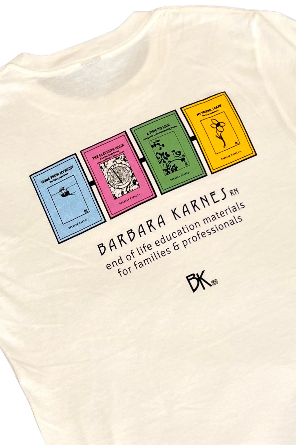 A white t-shirt backside with text that says Barbara Karnes, RN end of life education materials for families and professionals along with images of four booklets including Gone From My Sight.